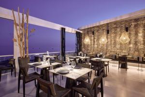 a restaurant with tables and chairs in a room at Artemis Seaside Resort in Paliochori