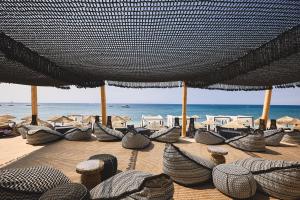 um grupo de cadeiras e guarda-sóis numa praia em Artemis Seaside Resort em Paliochori