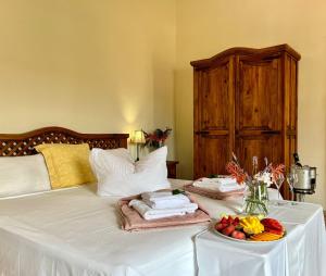 Una cama con una mesa con un plato de fruta. en Hotel Rural Nou Dalt Muntanya, en Orient
