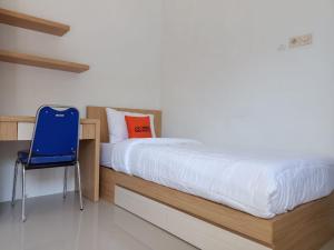 1 cama con silla azul en una habitación en KoolKost Female Syariah near Universitas Ahmad Dahlan Kampus 3 - Minimum Stay 30 Nights, en Timuran