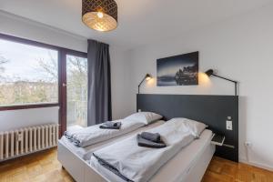 a bed in a room with a large window at Glück Auf Appartements Kammerstr. Duisburg in Duisburg