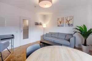 ein Wohnzimmer mit einem Sofa und einem Tisch in der Unterkunft Glück Auf Appartements Kammerstr. Duisburg in Duisburg