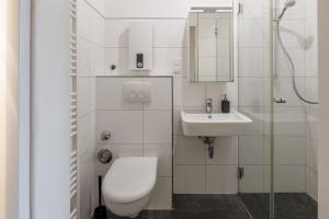 a white bathroom with a toilet and a sink at Glück Auf Appartements Kammerstr. Duisburg in Duisburg +28 photos