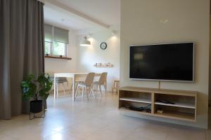 a living room with a flat screen tv and a table at Apartament Bukovy Wisła in Wisła