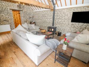 a living room with a white couch and a brick wall at The Old Stables in Chippenham