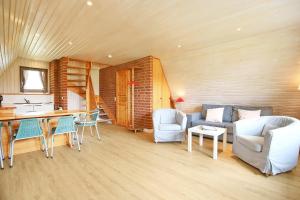 a living room with a couch and a table and chairs at An der Steilküste Finnhütte 05 in Boltenhagen +20 photos