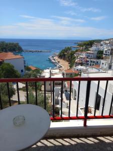 a bench on a balcony with a view of the ocean at George Rooms in Votsi