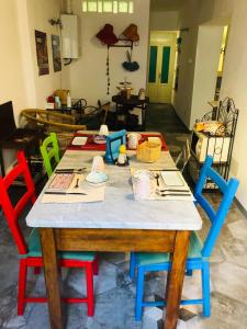 a table with four colorful chairs around it at B&B Castellani in Pavia