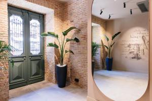 a room with a mirror and a plant next to a door at STROFI Boutique Hotel in Tbilisi City