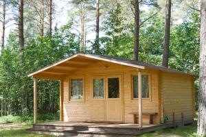 a small wooden cabin in the middle of a forest at Voosemetsa Turismitalu in Voose +16 photos