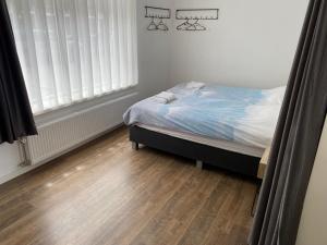 una camera con letto e pavimento in legno di HaagsHuisje- eigen appartement, dichtbij alles, stijlvol a Voorburg