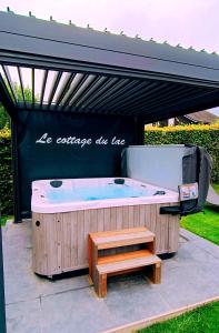 a jacuzzi tub with a bench and a table at Cottage du Lac Studio in Nivezé