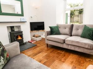 a living room with a couch and a fireplace at Chough Cottage in Penzance