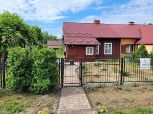 a gate to a house with a red roof at Dom pod Platanami in Bondyrz