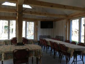 Sala de conferencias con mesas y sillas y TV de pantalla plana en Voosemetsa Turismitalu en Voose