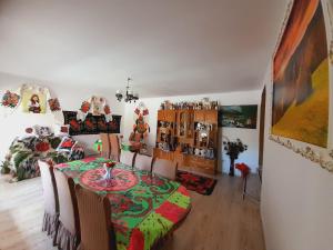 a dining room with a table and chairs and a room with at Casa de la ferma Mariuca in Berbeşti