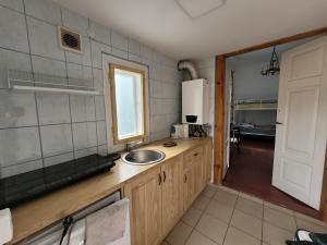 a small kitchen with a sink and a window at Dom pod Platanami in Bondyrz +3 photos