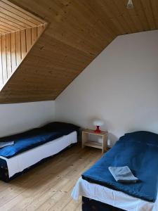 a bedroom with a bed and a wooden ceiling at Penzion Pláž in Slapy