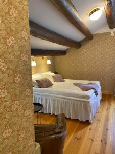 a hotel room with a bed and a chair at Bredsjö Gamla Herrgård White Dream Mansion in Hällefors