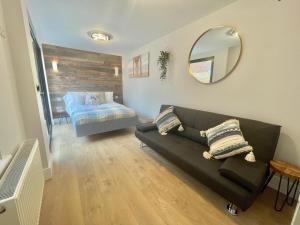 a living room with a couch and a bed at Coastline Retreats - Cloud9 Holiday Accommodation- 2 Bedroom self contained garden flat - Luxury bath, Netflix, Superfast Wifi, Parking included in Bournemouth