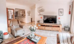 sala de estar con TV grande y mesa en Gold Pot Stay a 5 bedroom House, en Pretoria