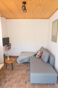 uma sala de estar com um sofá e uma mesa em ALTHEA - cozy with spacious terrace views em Galatas