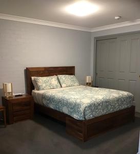 a bedroom with a bed and two tables and a door at Mudgee Apartments on Church Street in Mudgee