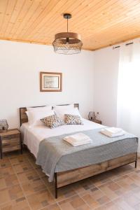 a bedroom with a bed and a wooden ceiling at ALTHEA - cozy with spacious terrace views in Galatas