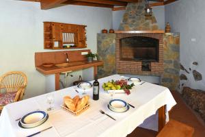 mesa con mantel blanco y chimenea en Villa Ivan, en Tijarafe