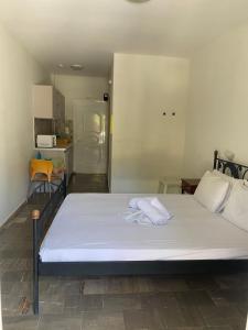 1 cama blanca grande en una habitación con cocina en Voula Ilias Studios en Panormos Kalymnos