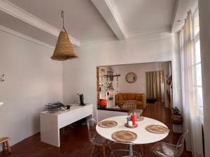 - un salon avec une table et des chaises blanches dans l'établissement Perpignan Appartement en plein centre historique, à Perpignan