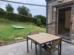 a wooden table and two chairs on a patio at Une Maison à la Campagne in Durbuy