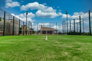 a tennis court with a net on a green field at Casa Rural CUESTA GRANDE in Mota del Cuervo