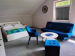 Noclegi Zator Energylandia في Spytkowice: غرفة نوم بسرير وكراسي زرقاء وطاولة