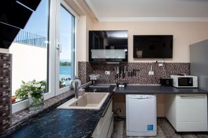 a kitchen with a sink and a large window at Aquamarine House in Tivat