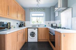 a kitchen with a washing machine and a window at Modern three bedroom home in Castle Donington in Castle Donington