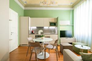 cocina y sala de estar con mesa y sillas en La Suite del Borghetto, en Pisa