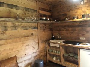 a kitchen with wooden walls and a sink at Une Maison à la Campagne in Durbuy