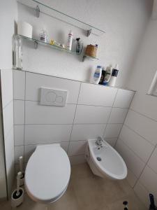 a white bathroom with a toilet and a sink at Apartment Lia in Beerfelden