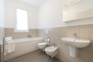 W łazience znajduje się umywalka, toaleta i wanna. w obiekcie Venice Golf residence w Lido di Venezia