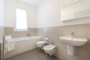 a bathroom with a sink and a toilet and a bath tub at Venice Golf residence in Venice-Lido