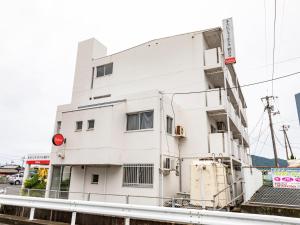 ein weißes Gebäude an der Seite einer Straße in der Unterkunft Tabist Motodai Business Hotel Kanonji in Kanonji