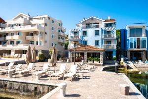 a row of apartment buildings with chairs and umbrellas at Aquamarine House in Tivat