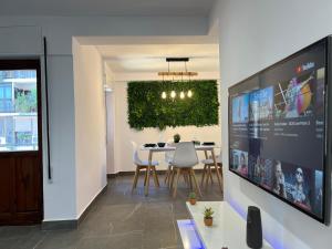 a dining room with a tv and a table with chairs at Apartamento espacioso de diseño a 3 min RENFE. in Córdoba