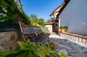 a wooden bench sitting next to a building at Grgurić Apartments in Rab