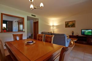 a living room with a wooden table and a television at Casas Golf Relax in Pals