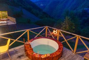 a hot tub on a deck with a table and chairs at Check Inn Merisi Spa and Resort in Gundauri