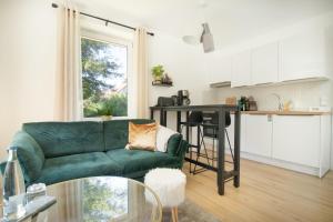 a living room with a green couch and a kitchen at Löwe Apartment Gold Tiengen Altstadt in Waldshut-Tiengen