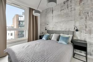 a bedroom with a large bed and a brick wall at Blue Mandarin - Chlebova Apartments in Gdańsk