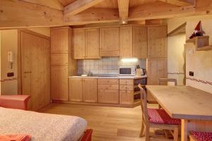 een keuken met houten kasten en een tafel in een kamer bij Baita dei ski app 5 in Livigno